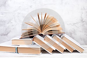 Open books, hardback colorful books on wooden table. gray concrete background. Back to school. Education