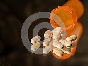 Open bottle of prescription opioids on black with copy space.