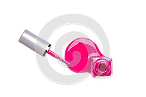 Open bottle with red nail polish. Spilled nail polish. Brush. White background.