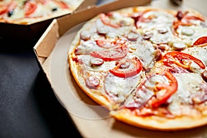 Open boxes with hot tasty italian sliced three pizzas on black background, delicious fast food, delivery concept, top view, copy s