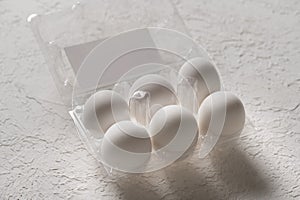 Open box with six whole white eggs on white background with clipping path