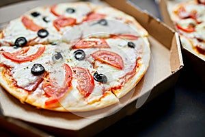 Open boxes with hot tasty italian sliced three pizzas on black background, delicious fast food, delivery concept, top view, copy s