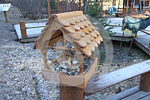 An open brown bird feeder installed on the railings in the Krasnoyarskie stolby national reserve