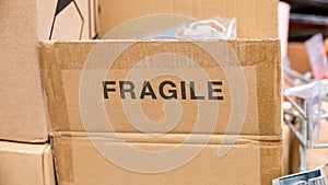 An open brown cardboard box with a FRAGILE label printed on it, opened carton container with a fragile contents materials inside.