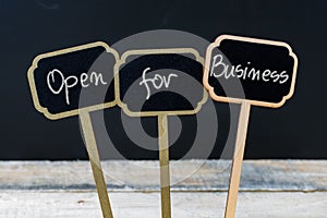 OPEN FOR BUSINESS message written with chalk on wooden mini blackboard labels