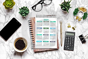 Open Calendar 2021, glasses, cup of coffee, pen, smartphone, succulents on marble table