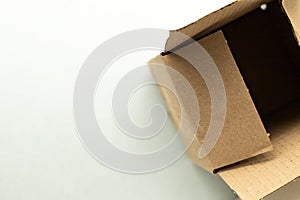 open cardboard box on soft blue background, top view