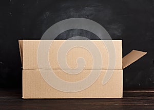 Open cardboard box stands on a brown table