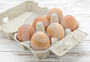 Open carton of brown organic eggs.
