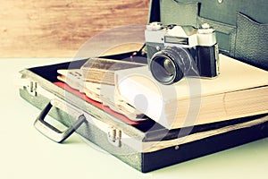 Open case with old camera sunglasses and clock