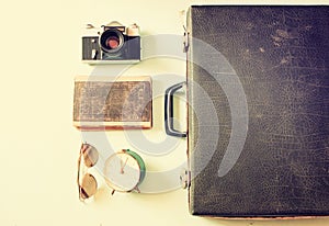 Open case with old camera sunglasses and clock.