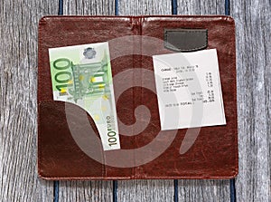 Open check folder with bill and euro