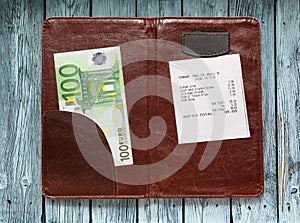 Open check folder with bill and euro