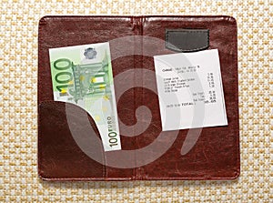 Open check folder with bill and euro