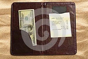 Open check folder with bill and money