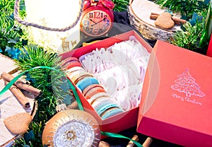 Open Christmas box with sweets and christmas decoration around