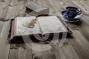 Open and closed Bibles with cup of tea