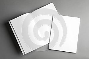Open and closed blank brochures on grey background, top view.