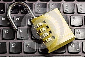 Open combination padlock on a laptop keyboard symbolizing data security