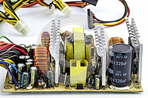 An open computer power supply at 220 volts with visible electronic components on the printed circuit board.