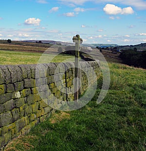 Open countryside with direction sign next to a dry stone wall