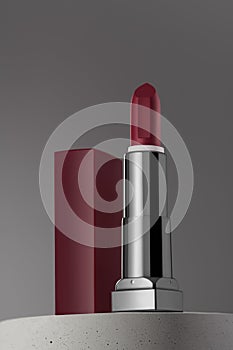 Open dark red lipstic on gray background and concrete podium