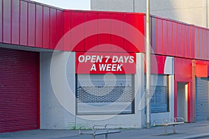 Open 7 days a week sign above business store front photo