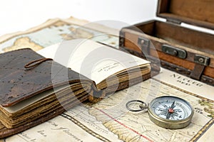 Open Diary Over Old Treasure Map with Compass