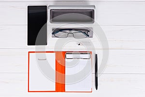 Open diary with a pen, glasses and open case for glasses near mo