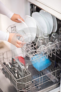 Open dishwasher with clean glass and dishes photo