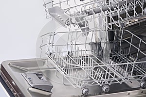 Open dishwasher door and empty extended grates for dirty dishes