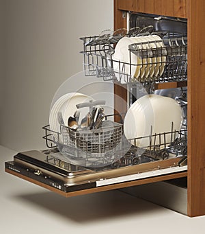 Open dishwasher loaded with cutlery and plates