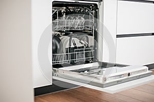 Open dishwasher in the white kitchen.