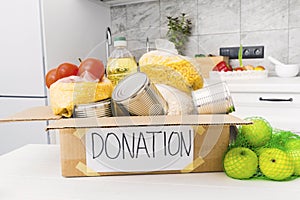 Open donation box with food in kitchen. Help for people. Charity concept