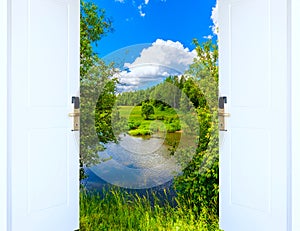 Open door with green meadow illuminated by bright sunshine