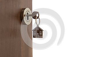 Open door to a new home. Key and home shaped keychain, isolated. Mortgage, investment, real estate, property and new home concept