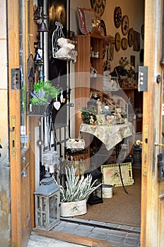 Open the door to the store where you can see hand made crafts and a lot of flowers