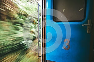 Open door in train wagon during it moving