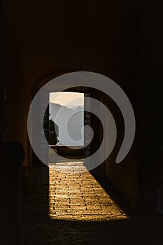 Through the open doors in the sunlight breaks an ancient fortress. Italy, Angera. Castle Rocca di Angera.