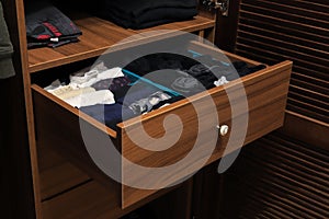 Open drawer with clothes in closet