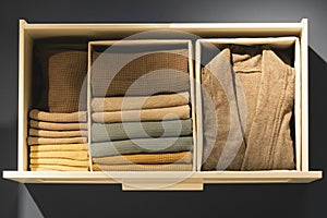 Open drawer with clothes. Vertical storage of clothing, tidying up, room cleaning. Top view