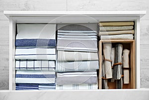 Open drawer with folded napkins and towels indoors, top view. Order in kitchen