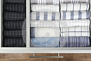 Open drawer with folded towels. Order in kitchen