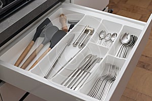 Open drawer with utensil set. Kitchen storage