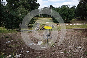 Open dry natural park with california live oak trees, rocks, and grass weeds and frisbee golf net