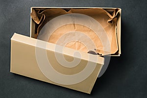 Open empty box with a lid, isolated on a black background. Cardboard box for shoes or gift. Top view, flat layout