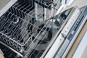 Open empty dishwasher machine close-up in modern kitchen