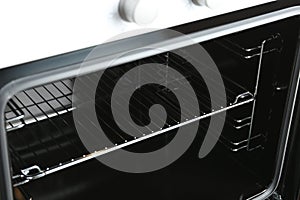 Open empty electric oven with rack