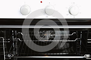 Open empty electric oven with rack