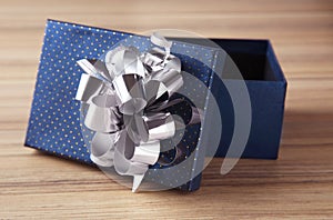 Open empty gift box with bow on table